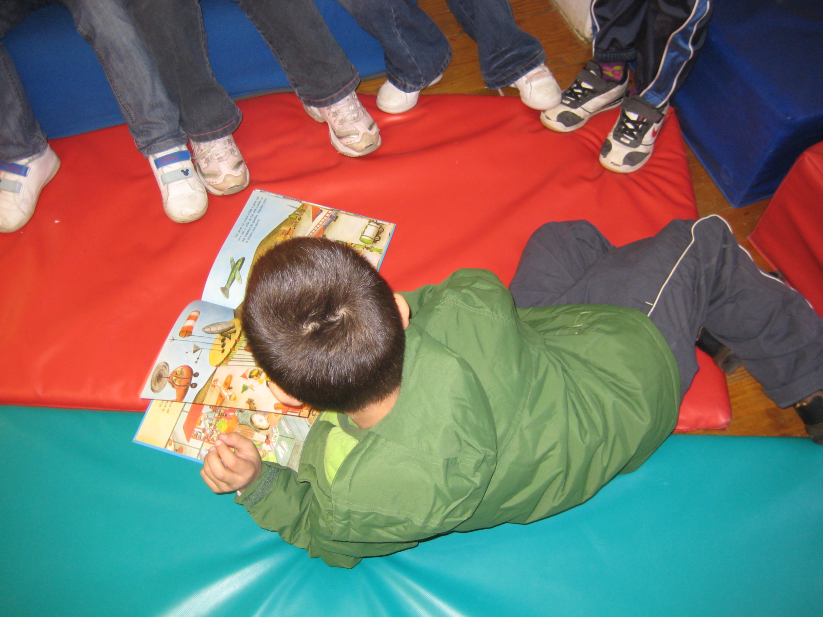 Criança deitada com um livro numa atividade em grupo