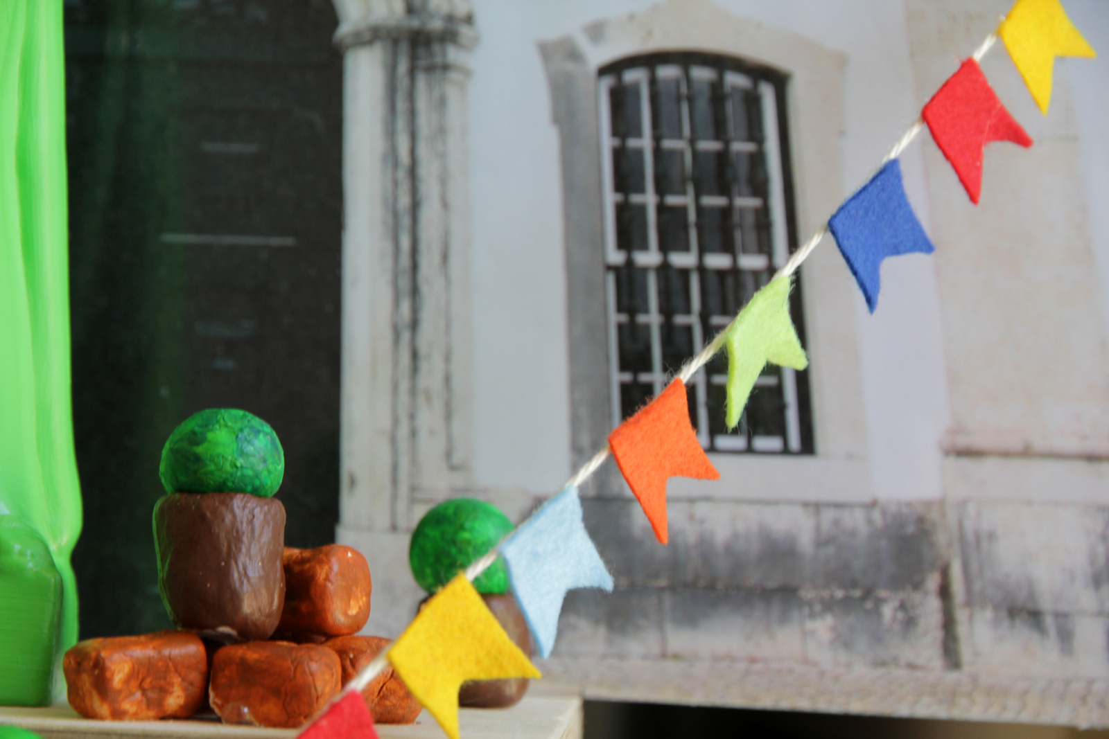 Banca com majericos artificiais e fita alusiva a arraial