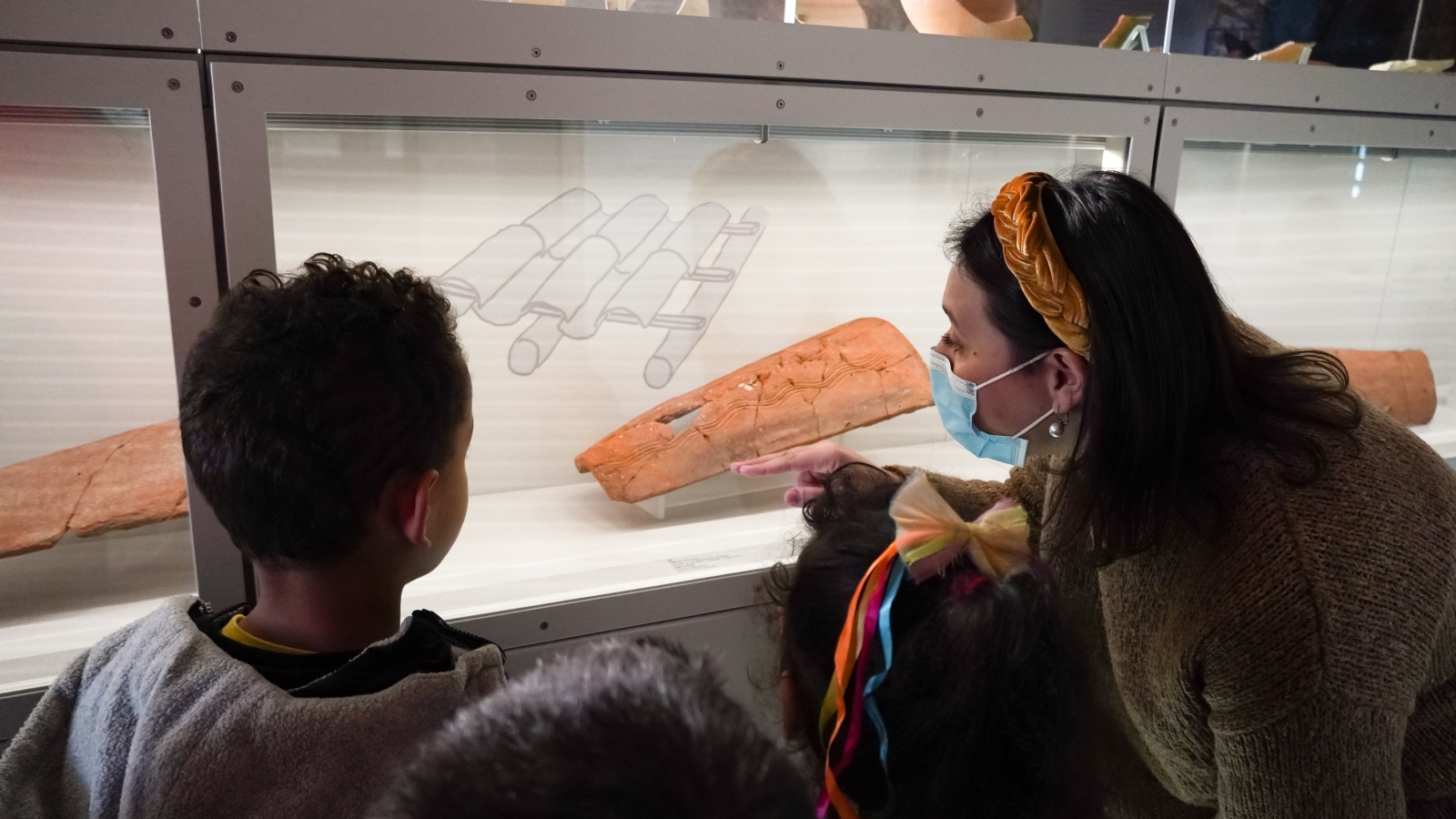 crianças e educadora observam uma peça do núcleo museológico do Castelo de São Jorge