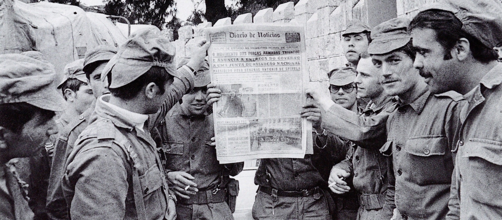 Fotografia a preto e branco, de tropas a segurarem o jornal Diário de Notícias na mão